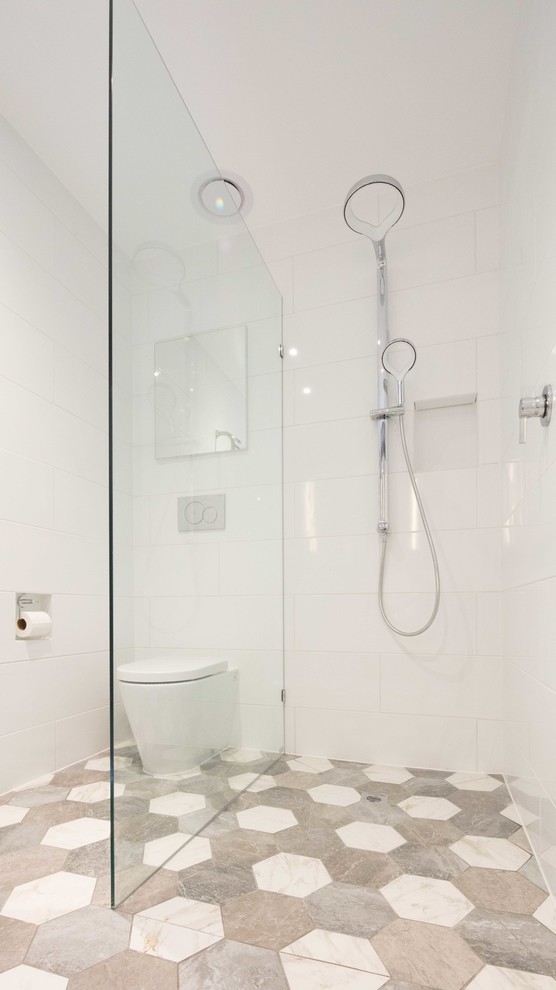 Immagine di una piccola stanza da bagno contemporanea con WC monopezzo, piastrelle bianche, piastrelle in ceramica, pareti bianche, pavimento in cementine, pavimento multicolore e doccia aperta