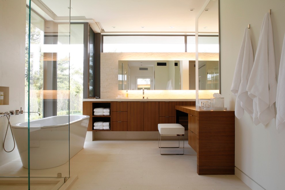 Aménagement d'une grande salle de bain principale contemporaine en bois brun avec une baignoire indépendante, des carreaux de porcelaine, un placard à porte plane, une douche d'angle, un mur blanc, sol en béton ciré et un carrelage beige.