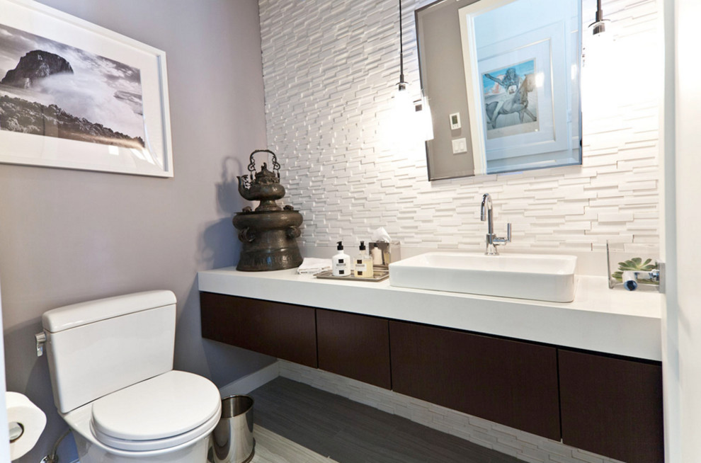 Cette image montre une salle d'eau asiatique en bois foncé de taille moyenne avec un placard à porte plane, WC séparés, un carrelage blanc, des carreaux en allumettes, un mur gris, sol en stratifié, une grande vasque et un sol gris.