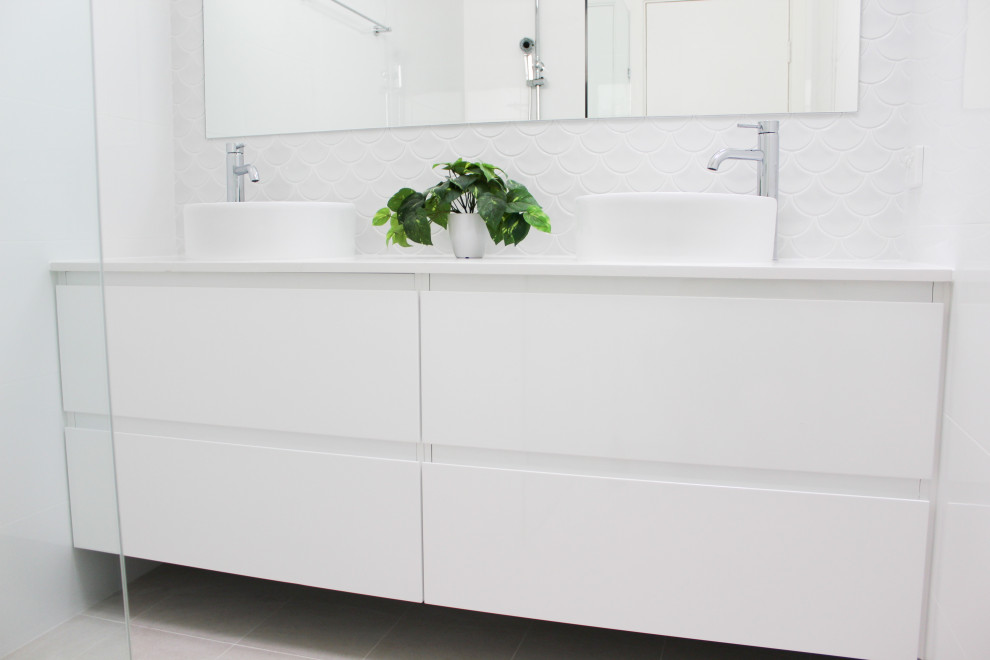 Idéer för små funkis vitt en-suite badrum, med släta luckor, vita skåp, en öppen dusch, vit kakel, keramikplattor, vita väggar, klinkergolv i porslin, ett fristående handfat, bänkskiva i kvarts, vitt golv och med dusch som är öppen