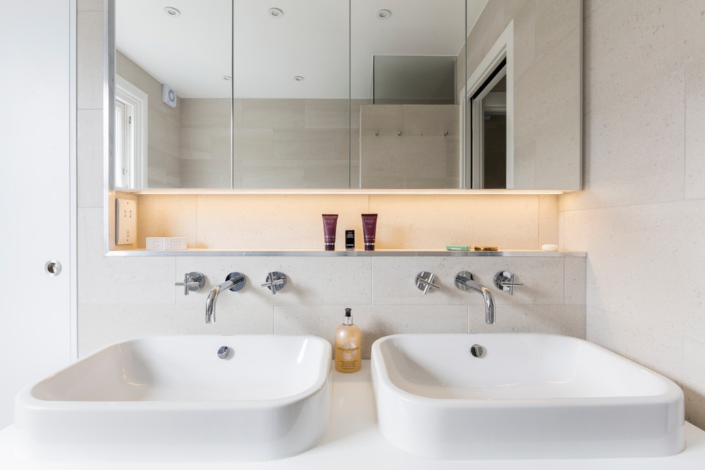 Small contemporary family bathroom in London with flat-panel cabinets, white cabinets, a built-in bath, a walk-in shower, a wall mounted toilet, beige tiles, porcelain tiles, beige walls, porcelain flooring, a built-in sink, quartz worktops, beige floors and a sliding door.
