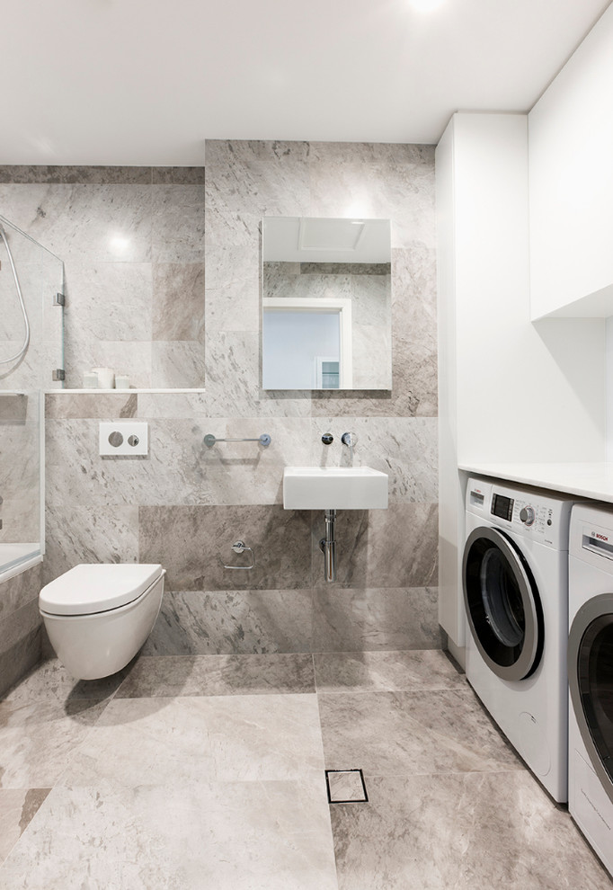 Immagine di una stanza da bagno padronale design con lavabo sospeso, vasca/doccia, WC sospeso e lavanderia