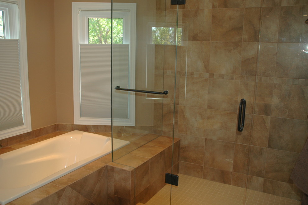 Bathroom - large contemporary master beige tile and porcelain tile porcelain tile bathroom idea in Toronto with an integrated sink, raised-panel cabinets, medium tone wood cabinets, solid surface countertops, a two-piece toilet and beige walls