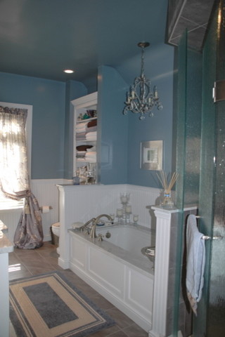Photo of a large traditional ensuite bathroom in Toronto with a submerged sink, beaded cabinets, white cabinets, marble worktops, a submerged bath, a corner shower, a two-piece toilet, grey tiles, porcelain tiles, blue walls and porcelain flooring.