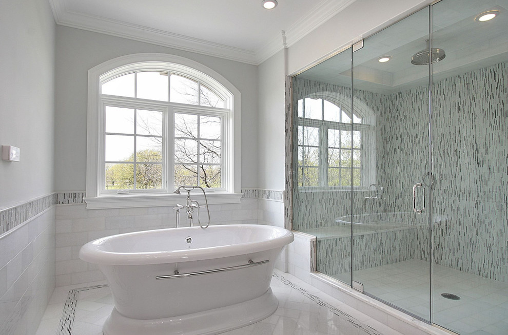 Стильный дизайн: большая главная ванная комната в стиле неоклассика (современная классика) с отдельно стоящей ванной, душем в нише, черно-белой плиткой, белой плиткой, удлиненной плиткой, белыми стенами и мраморным полом - последний тренд