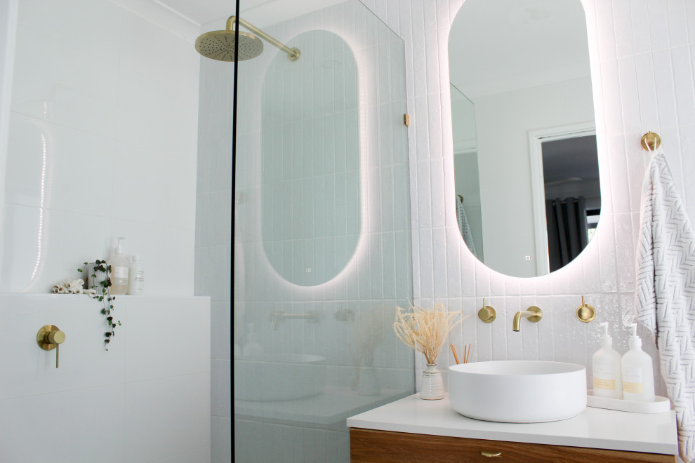 Пример оригинального дизайна: маленькая главная ванная комната в стиле модернизм с плоскими фасадами, темными деревянными фасадами, открытым душем, унитазом-моноблоком, белой плиткой, плиткой из сланца, белыми стенами, полом из керамогранита, настольной раковиной, столешницей из искусственного кварца, серым полом, открытым душем, белой столешницей, тумбой под одну раковину и подвесной тумбой для на участке и в саду