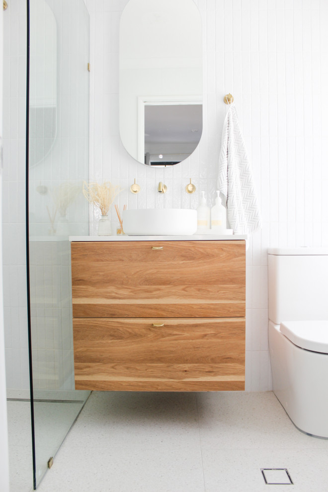 Inspiration for a small modern ensuite bathroom in Perth with flat-panel cabinets, dark wood cabinets, a walk-in shower, a one-piece toilet, white tiles, slate tiles, white walls, porcelain flooring, a vessel sink, engineered stone worktops, grey floors, an open shower, white worktops, a single sink and a floating vanity unit.