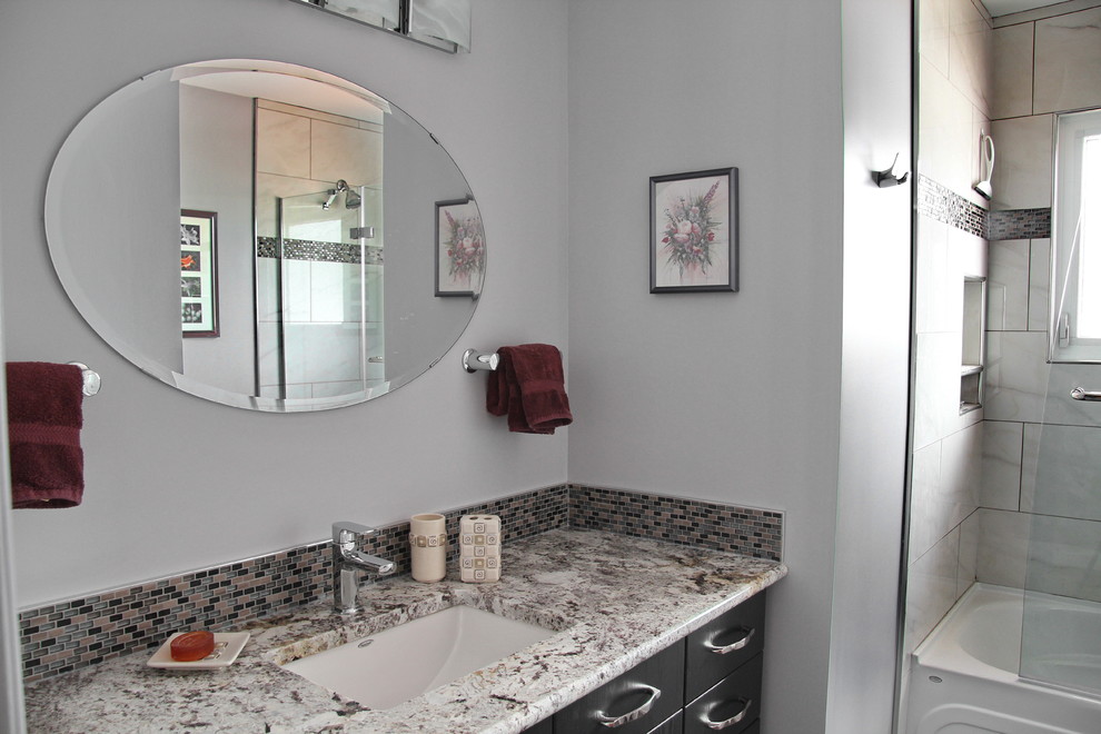 Medium sized traditional bathroom in Edmonton with grey walls, a submerged sink, flat-panel cabinets, black cabinets, an alcove bath, a shower/bath combination, grey tiles, white tiles, stone tiles and granite worktops.
