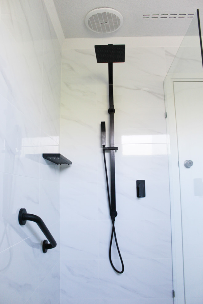 Inredning av ett litet svart svart badrum med dusch, med släta luckor, vita skåp, en öppen dusch, vit kakel, porslinskakel, vita väggar, klinkergolv i porslin, ett fristående handfat, bänkskiva i kvarts, grått golv och med dusch som är öppen