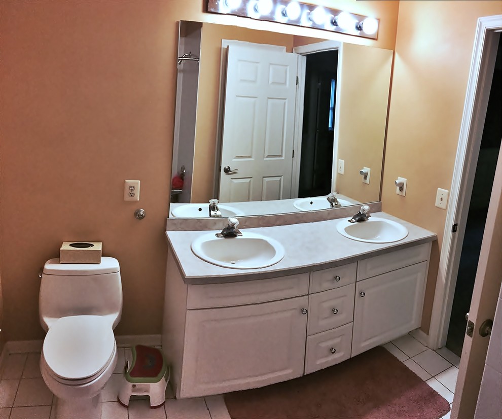 На фото: большая детская ванная комната в классическом стиле с фасадами с выступающей филенкой, белыми фасадами, ванной в нише, душем в нише, унитазом-моноблоком, белой плиткой, керамогранитной плиткой, оранжевыми стенами, полом из керамической плитки, накладной раковиной и столешницей из кварцита с