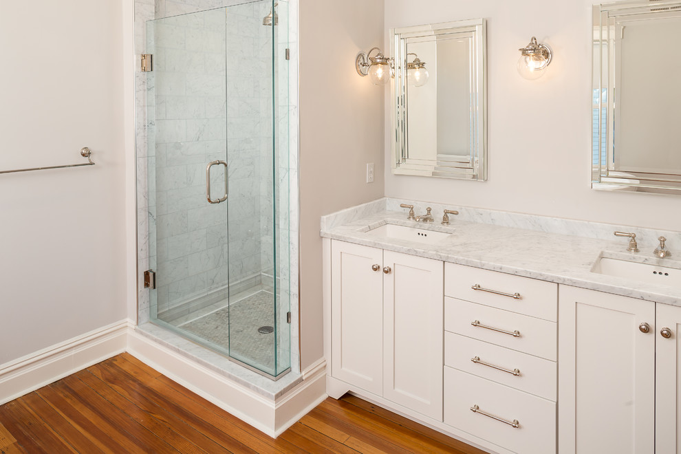 Exempel på ett stort klassiskt en-suite badrum, med skåp i shakerstil, vita skåp, en dusch i en alkov, grå kakel, vit kakel, stenkakel, ett undermonterad handfat, marmorbänkskiva, ett fristående badkar, grå väggar, mellanmörkt trägolv, brunt golv och dusch med gångjärnsdörr