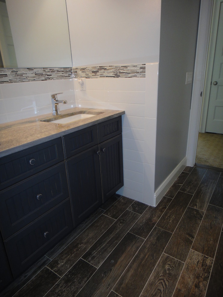 Foto på ett mellanstort funkis badrum med dusch, med ett undermonterad handfat, skåp i shakerstil, skåp i slitet trä, ett platsbyggt badkar, en dusch/badkar-kombination, en toalettstol med hel cisternkåpa, flerfärgad kakel, stickkakel och blå väggar