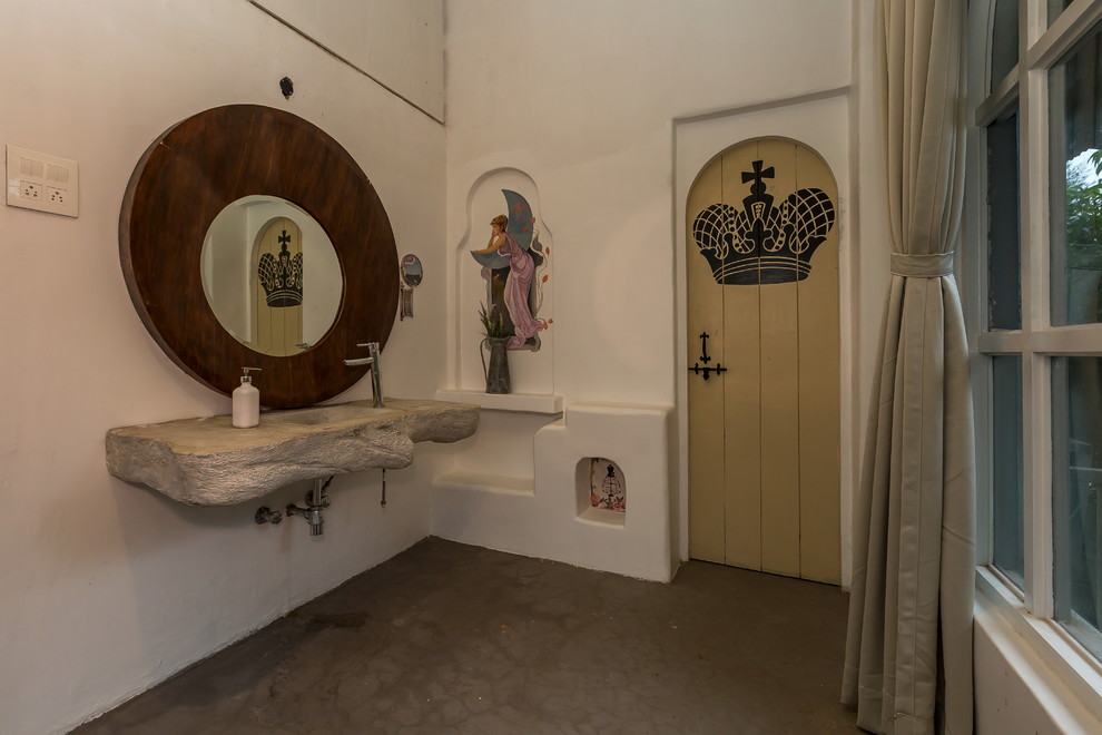 Modelo de cuarto de baño mediterráneo con paredes blancas, suelo de cemento, lavabo integrado, suelo gris y encimeras grises