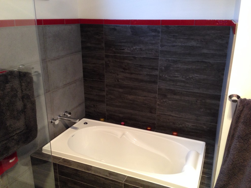 Medium sized contemporary bathroom in Newcastle - Maitland with flat-panel cabinets, white cabinets, engineered stone worktops, a built-in bath, black tiles, porcelain tiles, white walls and porcelain flooring.
