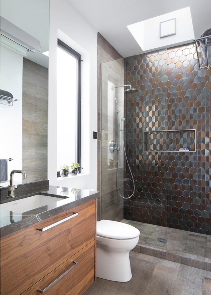 Modern inredning av ett grå grått badrum, med släta luckor, marmorbänkskiva och med dusch som är öppen