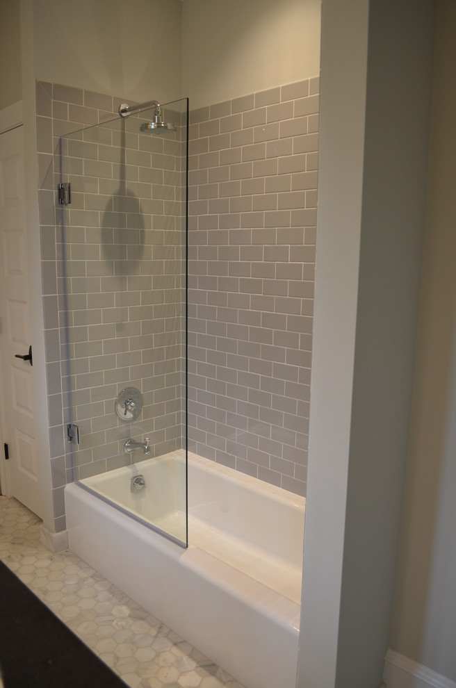 На фото: ванная комната среднего размера в стиле неоклассика (современная классика) с врезной раковиной, плоскими фасадами, белыми фасадами, ванной в нише, серой плиткой и серыми стенами с