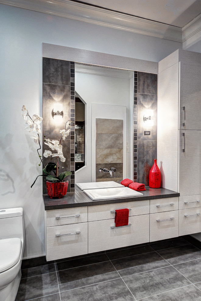 Small contemporary bathroom in Ottawa with a built-in sink, flat-panel cabinets, grey cabinets, laminate worktops, an alcove bath, a one-piece toilet, grey tiles, ceramic tiles, grey walls and ceramic flooring.