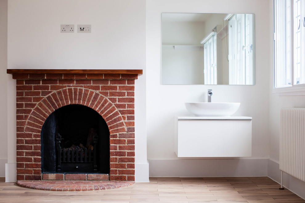 Exemple d'une salle de bain tendance avec des portes de placard blanches, un mur blanc, parquet clair, une vasque, un plan de toilette en bois et un plan de toilette blanc.