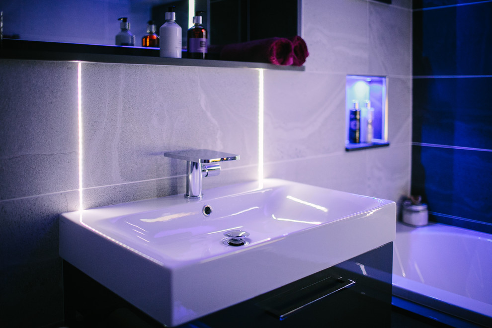 This is an example of a small contemporary family bathroom in Other with a built-in bath, a one-piece toilet and a console sink.