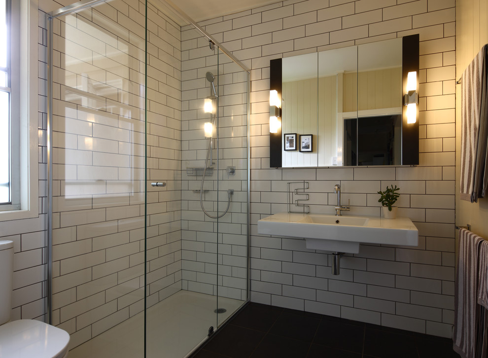 Idéer för ett modernt badrum, med ett väggmonterat handfat, en hörndusch, vit kakel och tunnelbanekakel