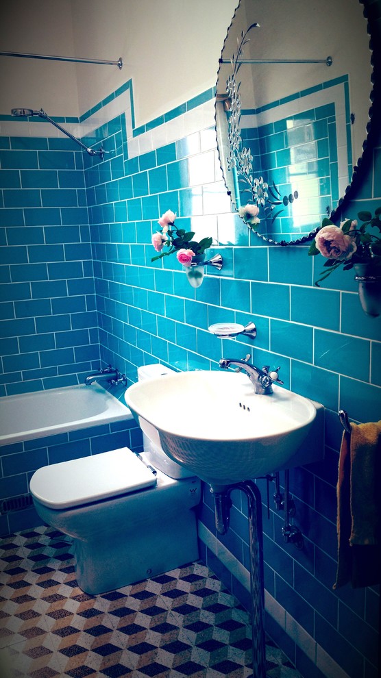 Idée de décoration pour une petite salle d'eau vintage en bois brun avec un lavabo suspendu, un placard en trompe-l'oeil, une baignoire posée, un combiné douche/baignoire, WC séparés, un carrelage bleu, des carreaux de céramique, un mur bleu et un sol en travertin.