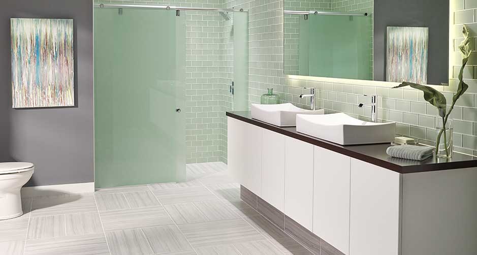 Inspiration for a medium sized modern ensuite bathroom in Orlando with flat-panel cabinets, white cabinets, a corner shower, a one-piece toilet, grey tiles, glass tiles, grey walls, porcelain flooring, a vessel sink, solid surface worktops, grey floors and a sliding door.