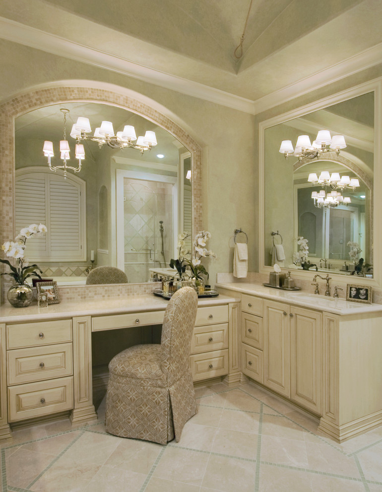 This is an example of a large traditional ensuite bathroom in Houston with raised-panel cabinets, beige cabinets, beige tiles, stone tiles, green walls, travertine flooring and a submerged sink.