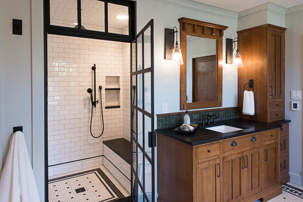 Réalisation d'une grande salle de bain principale en bois brun avec WC à poser, un carrelage vert, un mur vert, un plan de toilette noir, un banc de douche et meuble-lavabo encastré.