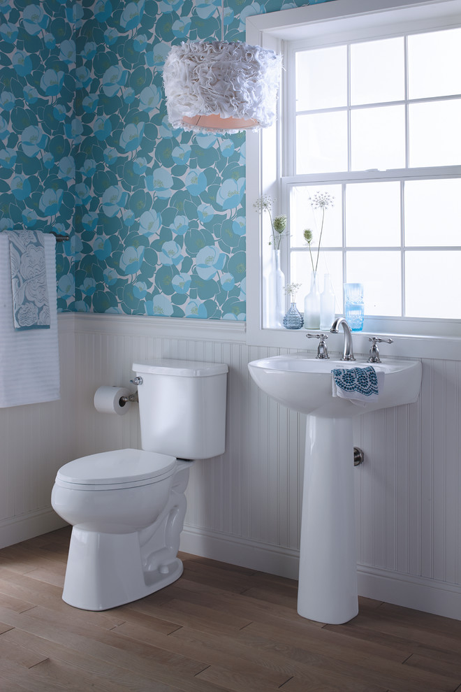 Eklektisk inredning av ett litet badrum med dusch, med ett piedestal handfat, en toalettstol med separat cisternkåpa, flerfärgade väggar och ljust trägolv