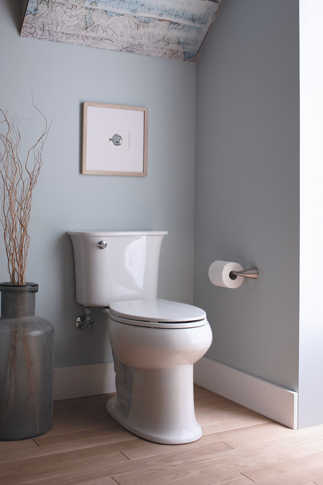 Exempel på ett mellanstort toalett, med en toalettstol med separat cisternkåpa, blå väggar och ljust trägolv
