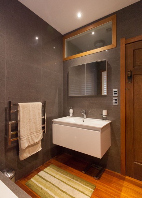 Diseño de cuarto de baño actual con armarios tipo mueble, puertas de armario blancas, baldosas y/o azulejos grises, baldosas y/o azulejos de porcelana, encimera de acrílico y encimeras blancas