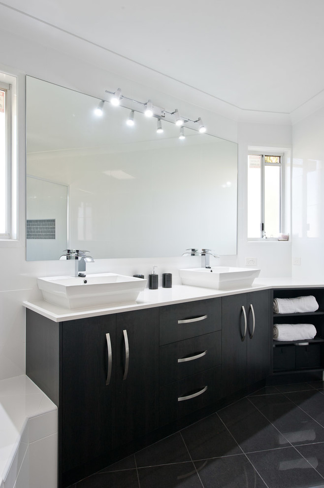 Bild på ett mellanstort funkis en-suite badrum, med släta luckor, svarta skåp, ett platsbyggt badkar, en hörndusch, porslinskakel, vita väggar, klinkergolv i porslin, ett fristående handfat och dusch med gångjärnsdörr