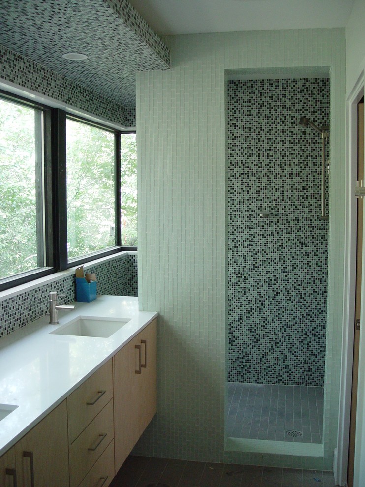 Ispirazione per una stanza da bagno minimalista con piastrelle a mosaico, doccia aperta, top in superficie solida, lavabo sottopiano e piastrelle verdi