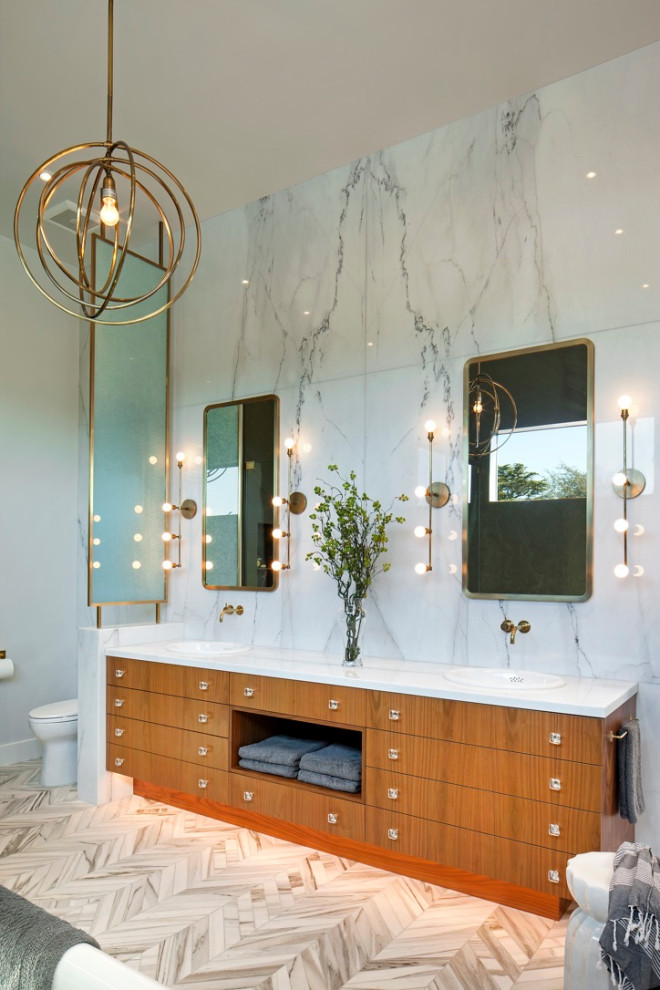 Großes Modernes Badezimmer En Suite mit flächenbündigen Schrankfronten, hellbraunen Holzschränken, Wandtoilette mit Spülkasten, grauen Fliesen, Porzellanfliesen, grauer Wandfarbe, Einbauwaschbecken, beigem Boden und weißer Waschtischplatte in Los Angeles