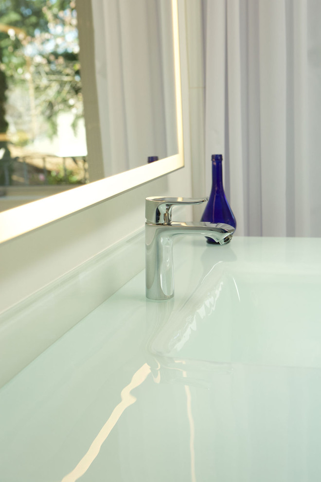 Пример оригинального дизайна: большая главная ванная комната в современном стиле с плоскими фасадами, светлыми деревянными фасадами, японской ванной, душем без бортиков, унитазом-моноблоком, белой плиткой, керамической плиткой, белыми стенами, полом из керамической плитки, монолитной раковиной, столешницей из переработанного стекла, белым полом, шторкой для ванной и белой столешницей