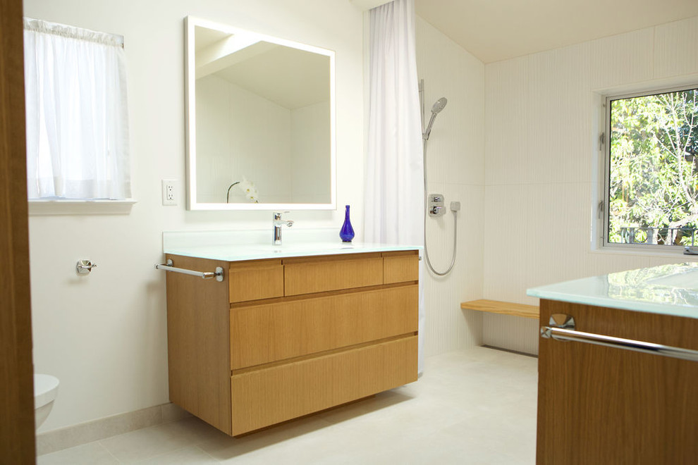 На фото: большая главная ванная комната с плоскими фасадами, светлыми деревянными фасадами, японской ванной, душем без бортиков, унитазом-моноблоком, белой плиткой, керамической плиткой, белыми стенами, полом из керамической плитки, монолитной раковиной, столешницей из переработанного стекла, белым полом, шторкой для ванной и белой столешницей с