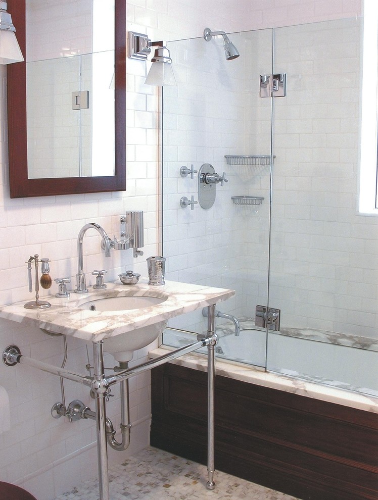 ニューヨークにある高級な中くらいなトラディショナルスタイルのおしゃれなマスターバスルーム (サブウェイタイル、シャワー付き浴槽	、コンソール型シンク、オープンシェルフ、アルコーブ型浴槽、白いタイル、白い壁、大理石の床、大理石の洗面台) の写真