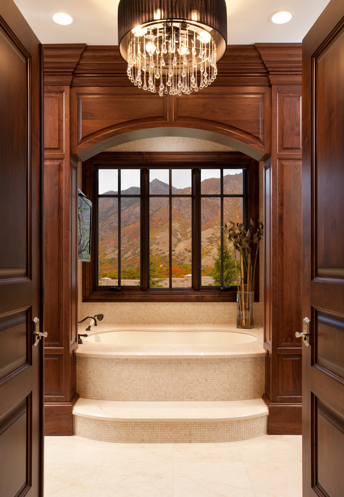 Cette image montre une salle de bain traditionnelle avec une baignoire en alcôve et un carrelage beige.