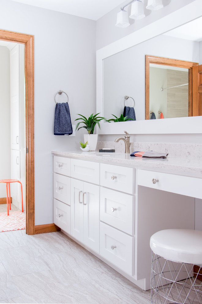 Aménagement d'une salle de bain classique avec des portes de placard blanches, un placard à porte shaker, un mur gris, un lavabo encastré, un sol gris et un plan de toilette gris.