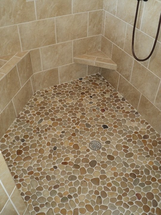 This is an example of a bathroom in Atlanta with a corner shower and pebble tile flooring.