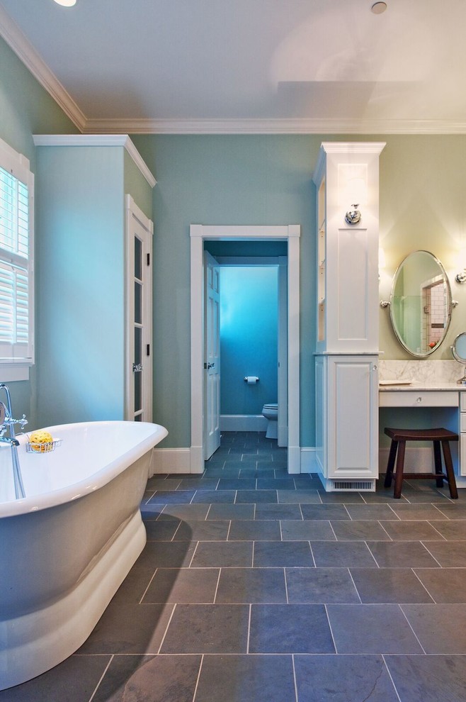 Идея дизайна: главная ванная комната среднего размера в классическом стиле с фасадами с утопленной филенкой, белыми фасадами, отдельно стоящей ванной, душевой комнатой, белой плиткой, плиткой из листового камня, синими стенами, полом из сланца, врезной раковиной, мраморной столешницей и душем с распашными дверями