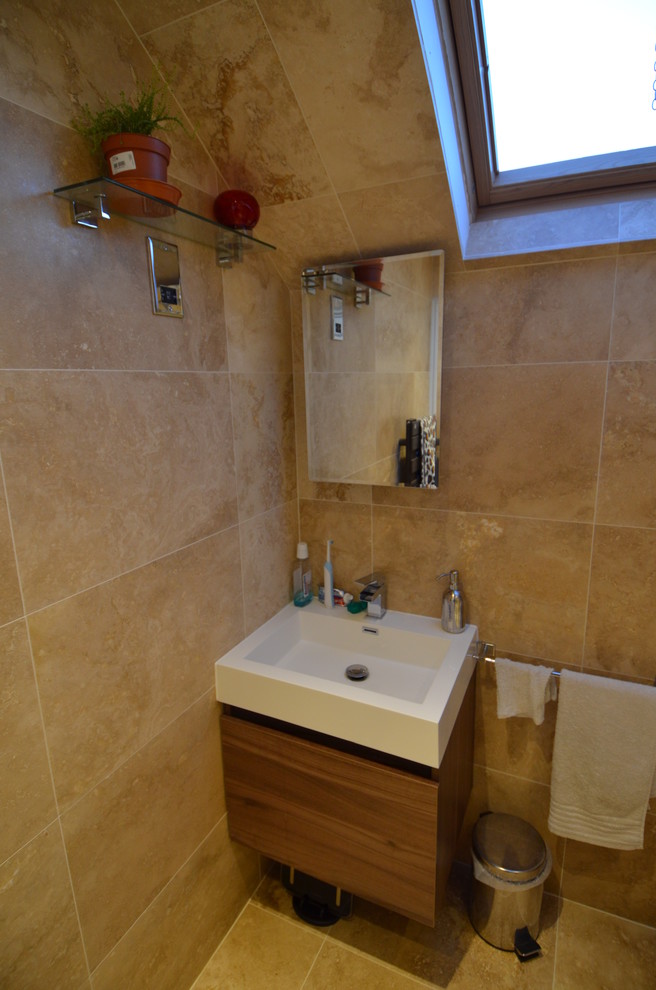 Design ideas for a small contemporary bathroom in Gloucestershire with a trough sink, flat-panel cabinets, dark wood cabinets, solid surface worktops, a corner shower, a two-piece toilet, beige tiles, stone tiles, beige walls and travertine flooring.