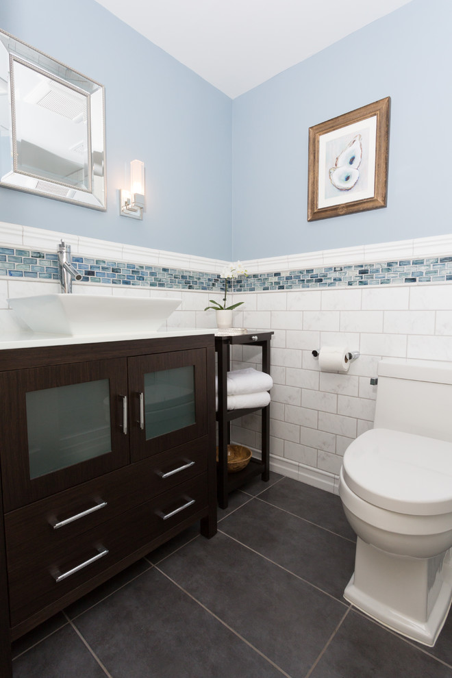 Example of a small transitional 3/4 white tile and subway tile ceramic tile alcove shower design in Chicago with glass-front cabinets, dark wood cabinets, a one-piece toilet, blue walls, a vessel sink, quartz countertops and a hinged shower door