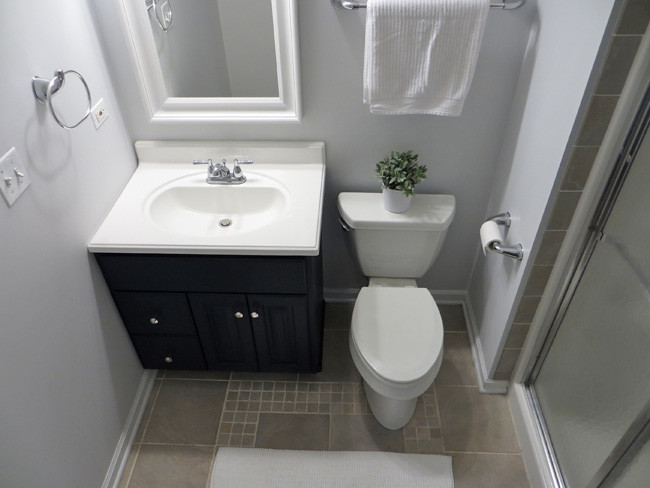 Cette photo montre une petite salle de bain moderne avec un mur gris, un sol en carrelage de terre cuite et des portes de placard noires.