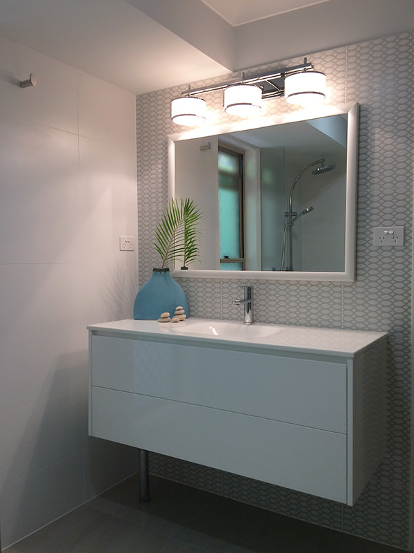 На фото: маленькая ванная комната в стиле неоклассика (современная классика) с белыми фасадами, ванной в нише, серой плиткой, керамической плиткой, серыми стенами, полом из керамической плитки, монолитной раковиной, стеклянной столешницей, серым полом и душем с распашными дверями для на участке и в саду