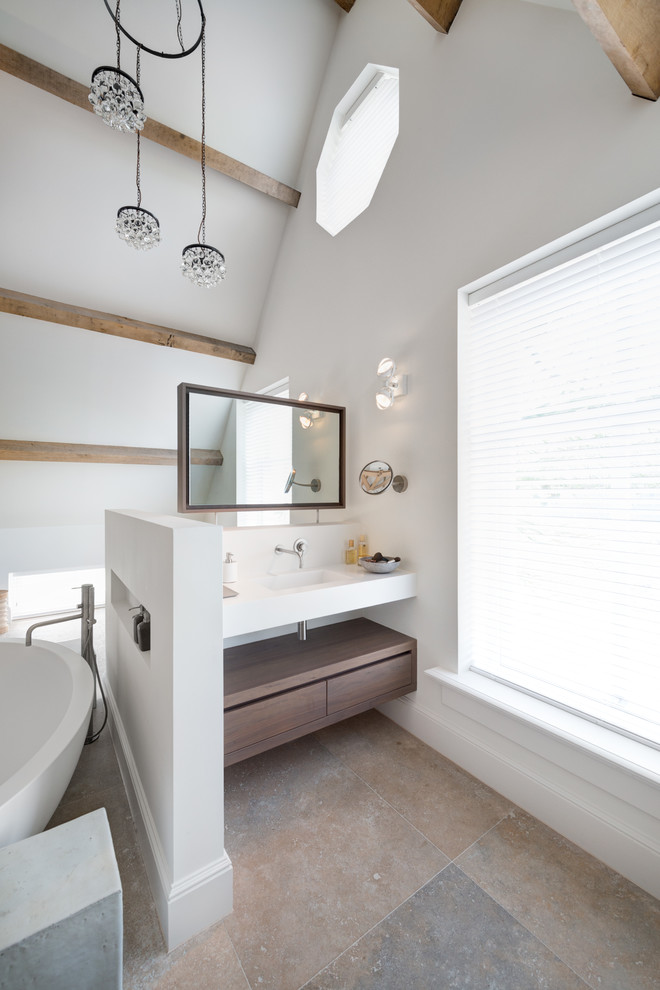 Foto de cuarto de baño contemporáneo con armarios con paneles lisos, puertas de armario de madera en tonos medios, bañera exenta y paredes blancas
