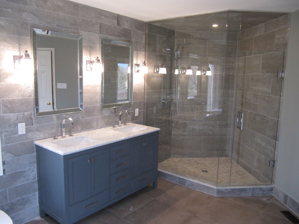 Inredning av ett modernt stort vit vitt en-suite badrum, med möbel-liknande, grå skåp, ett fristående badkar, en hörndusch, en toalettstol med separat cisternkåpa, grå kakel, porslinskakel, gröna väggar, klinkergolv i porslin, ett undermonterad handfat, marmorbänkskiva, brunt golv och dusch med gångjärnsdörr