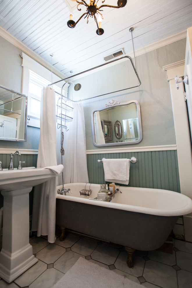 Пример оригинального дизайна: маленькая ванная комната в стиле кантри с раковиной с пьедесталом, ванной на ножках, серой плиткой, каменной плиткой, мраморным полом, шторкой для ванной, душем над ванной, серыми стенами, душевой кабиной и серым полом для на участке и в саду