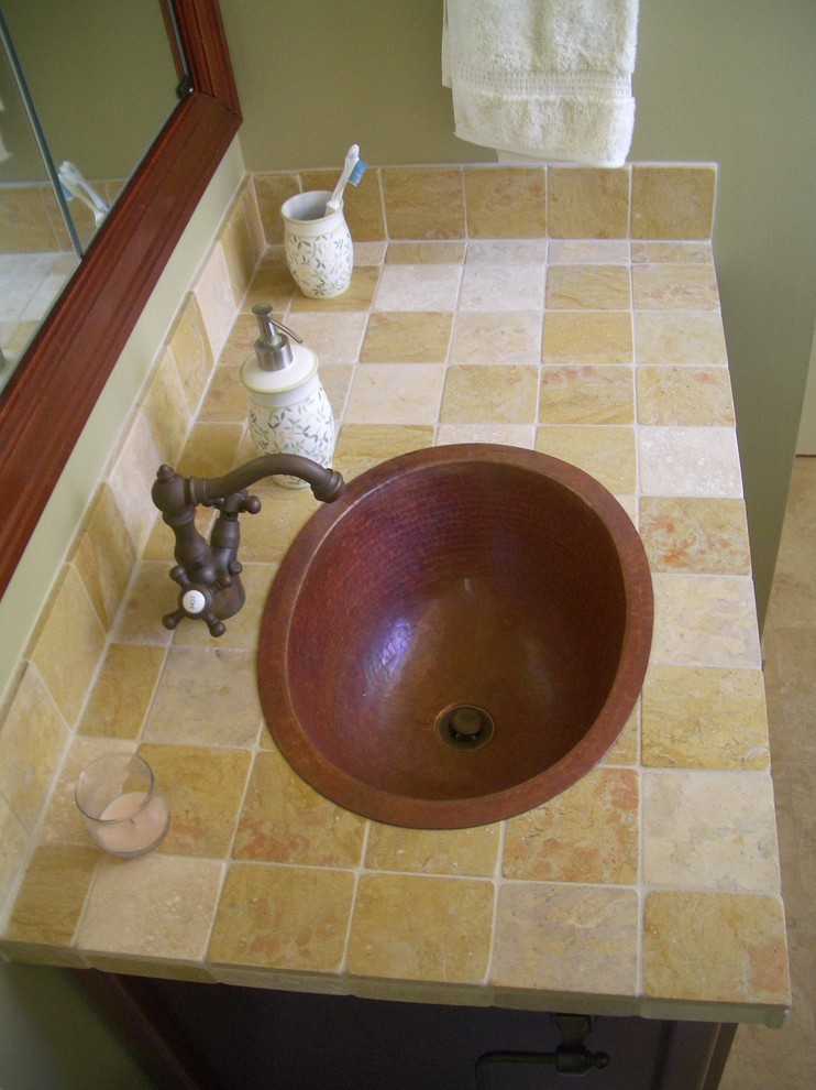 Inspiration pour une petite salle de bain traditionnelle en bois foncé avec un placard à porte shaker, WC séparés, un carrelage beige, un carrelage de pierre, un mur vert, un sol en travertin, un lavabo posé et un plan de toilette en carrelage.