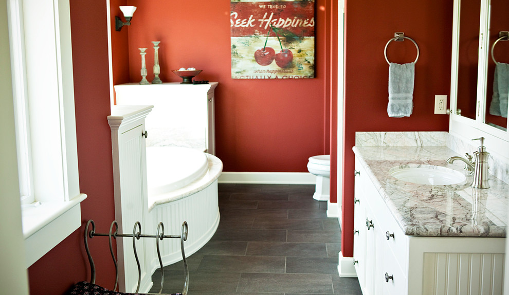Mid-sized master travertine floor drop-in bathtub photo in Portland with a drop-in sink, flat-panel cabinets, white cabinets, marble countertops and red walls